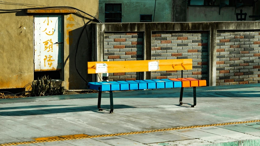 some colorful boxes sit on a bench near the street
