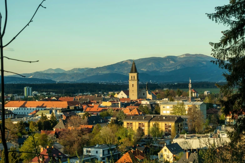 city with church steeple and trees in foreground