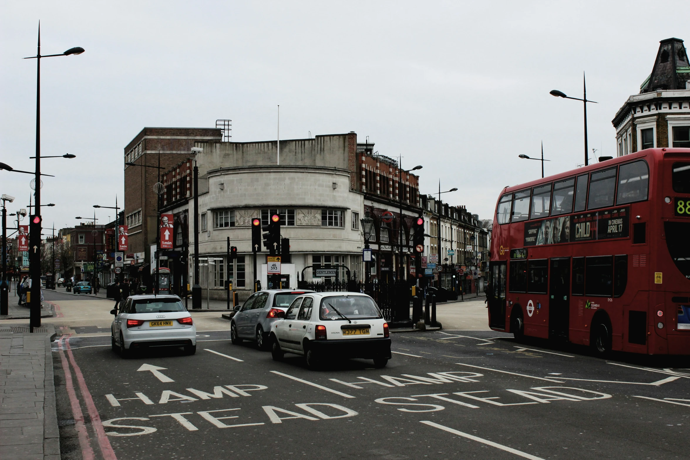 a red double decker bus is on the street near other vehicles