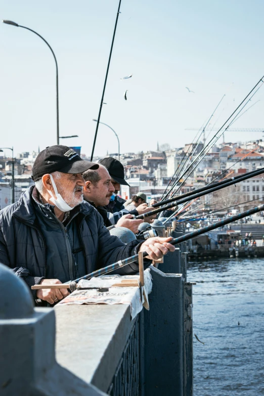 two men standing next to each other fishing