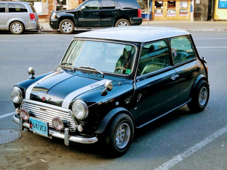 a small black car parked on the side of the road