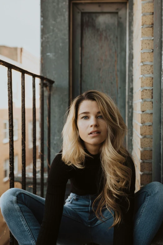 a young woman sits on the ground in front of a door