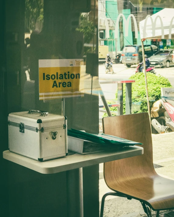 an office space outside with an office chair and table that says isolation area