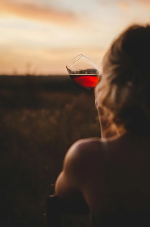 a close up of a person holding a glass of wine