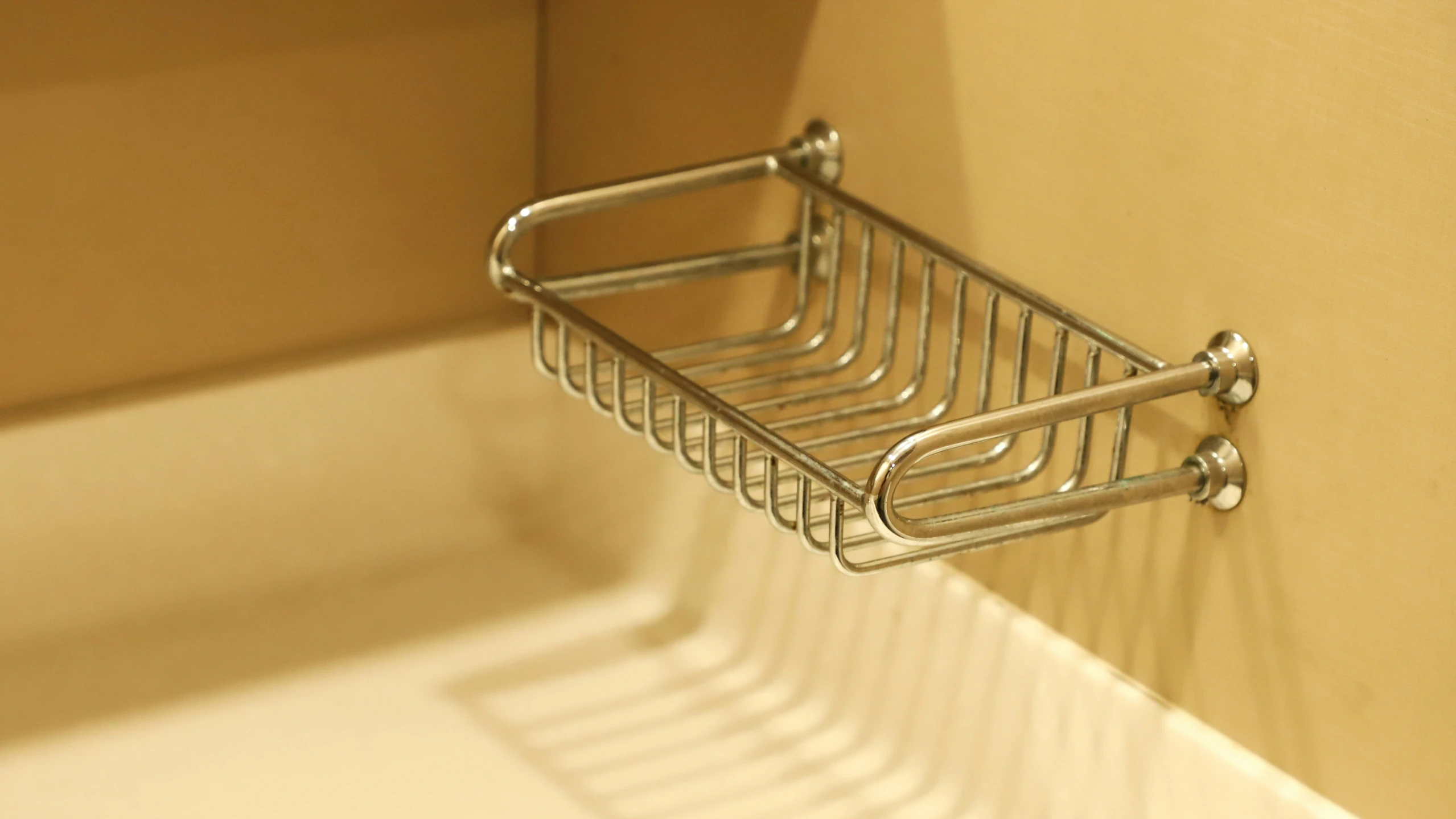 a shelf in a shower with a towel basket