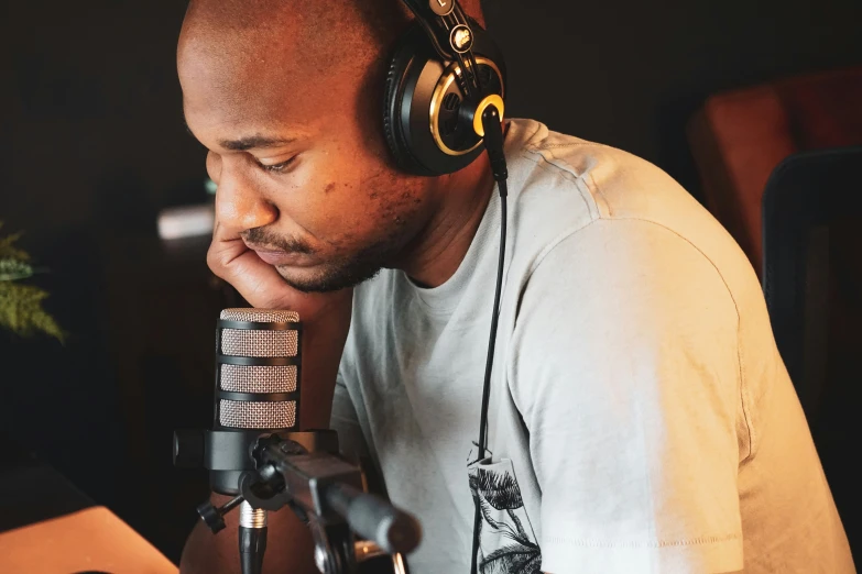 man with headphones and microphone in recording studio