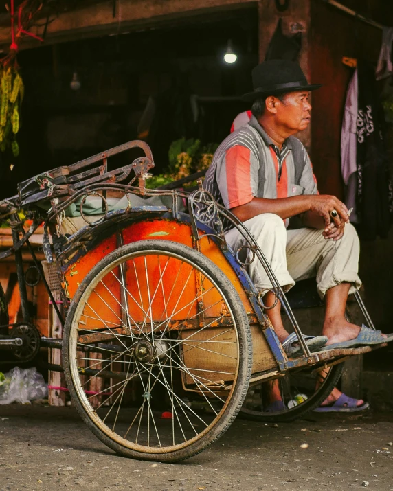 a man sitting on top of a bike with lots of wheels