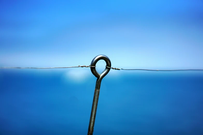 a metal object floating on water next to some rope