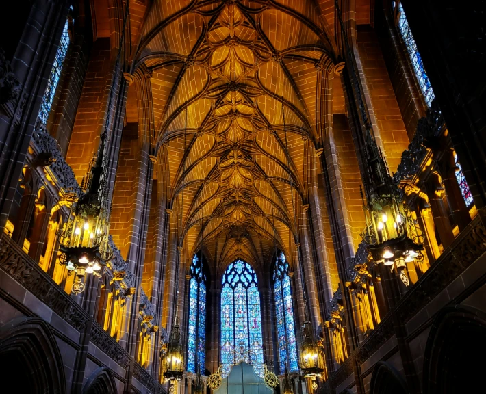 the ceiling of an ornate cathedral with stained glass windows