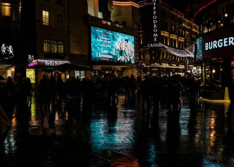 a dark city street with several large billboards