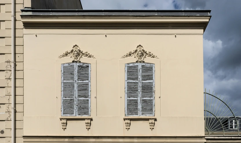 a tall building with two windows with ornate trim