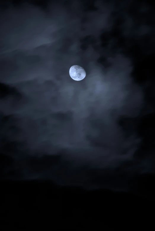 the moon shines through clouds at night