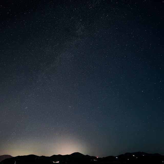 many stars are visible in the sky above the ocean