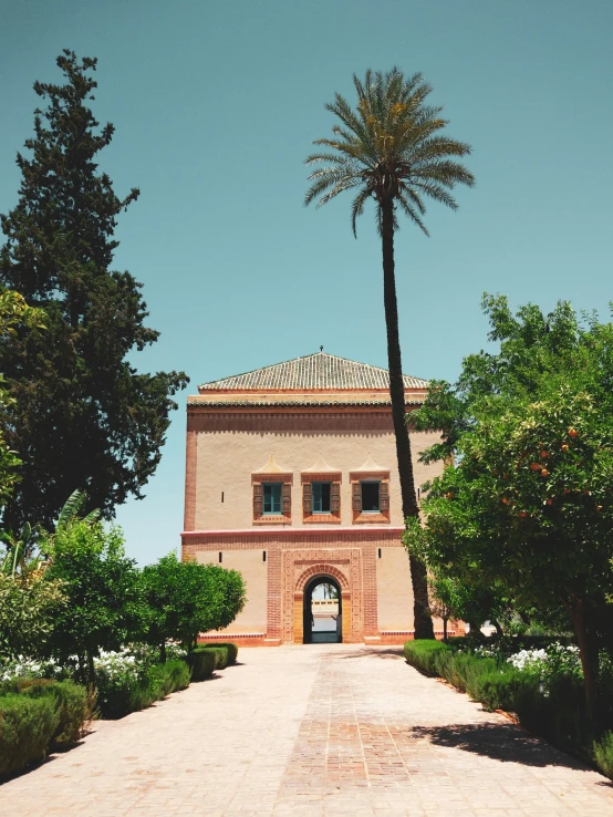 a brick building sitting between two tall trees