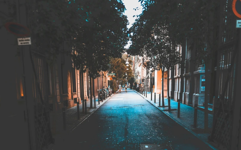 a narrow road with a street sign on the side