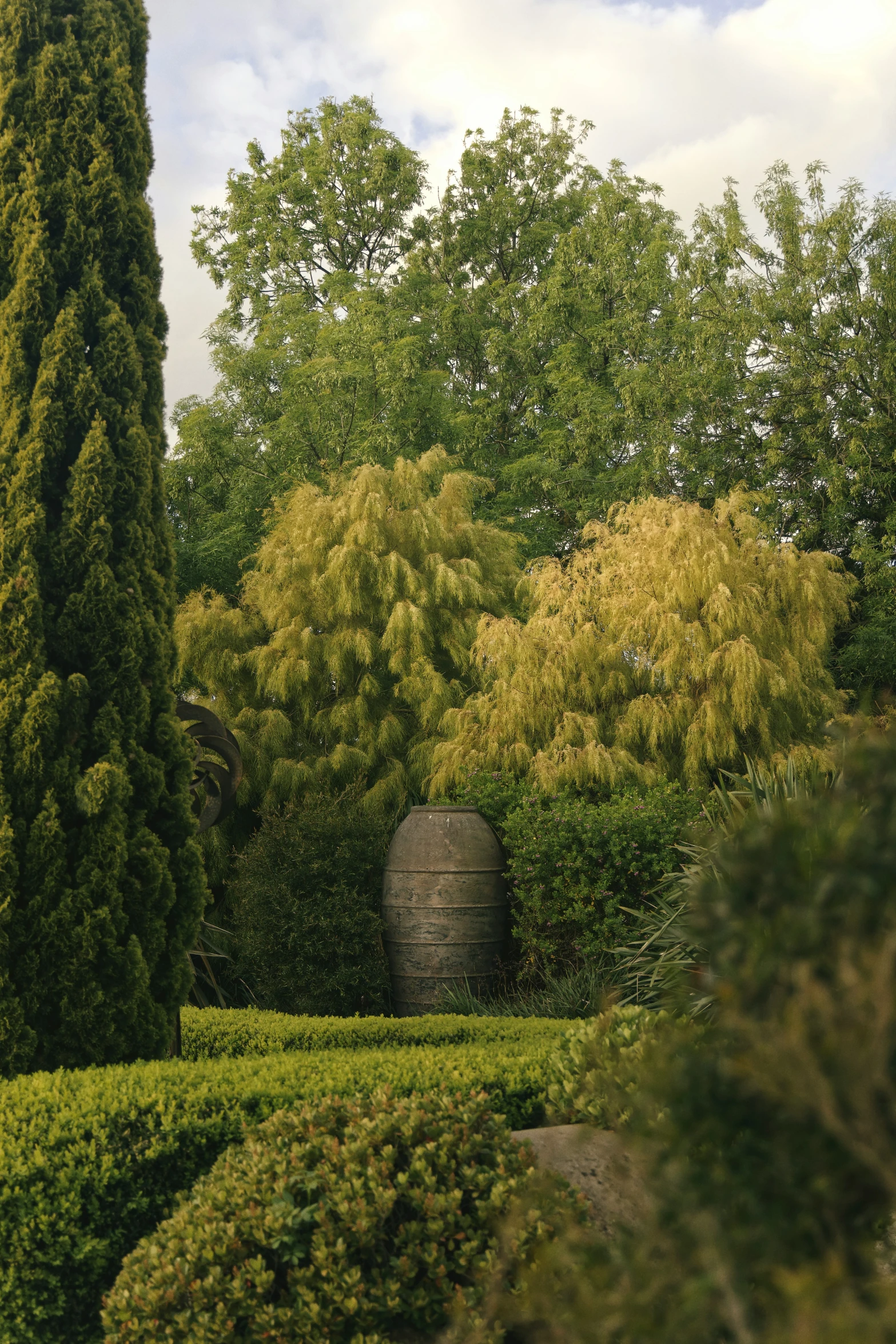 the large wooden barrel is in the middle of a garden