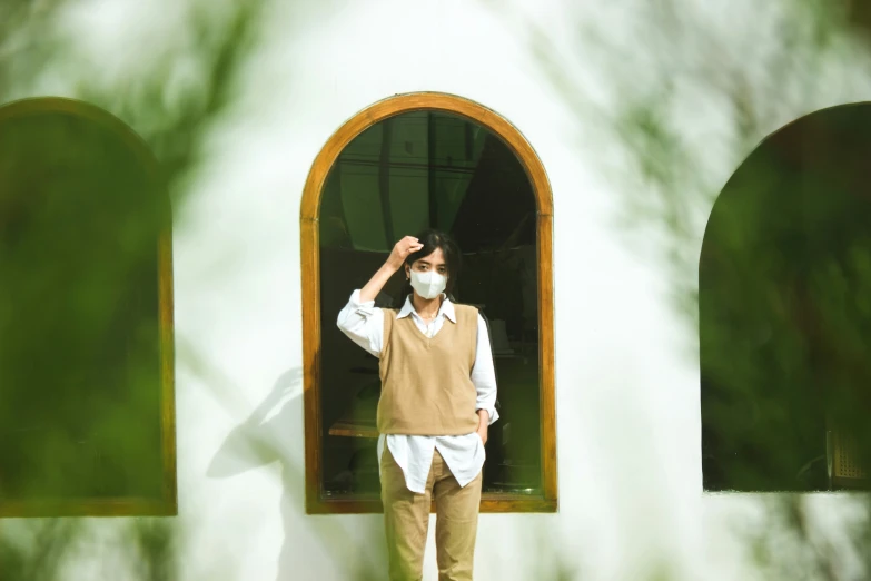 man wearing brown vest and white shirt in front of a green window