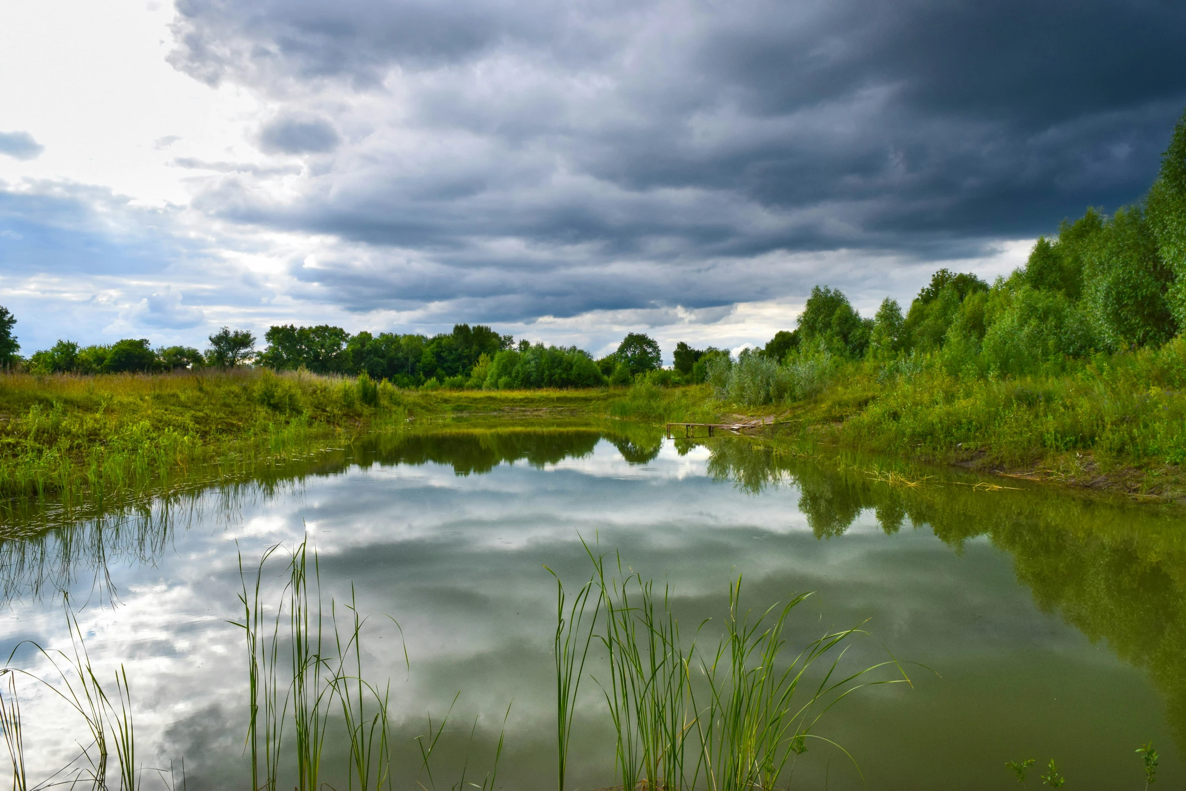 the river is quiet with many clouds above it