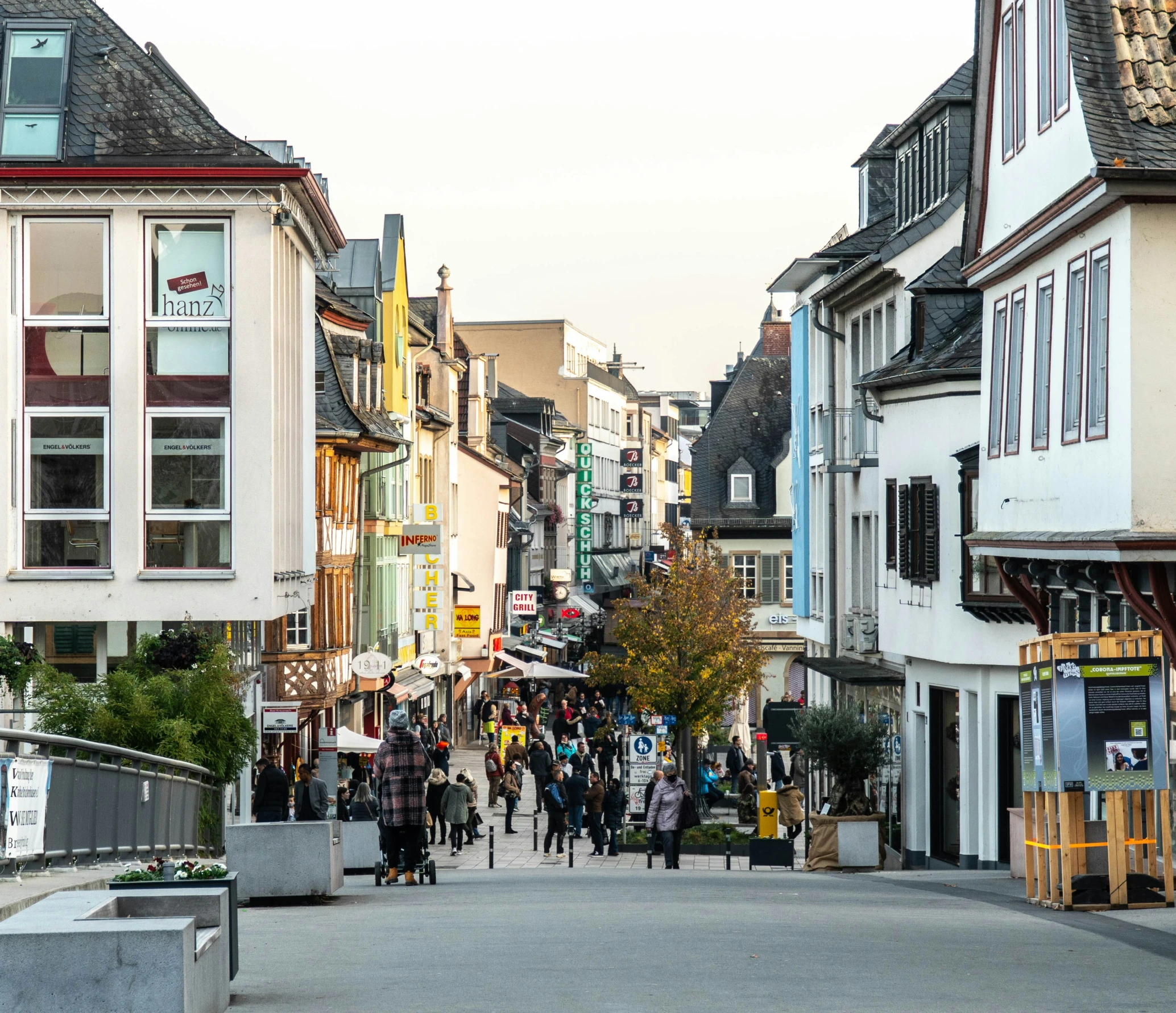 a group of people walking down a narrow city street