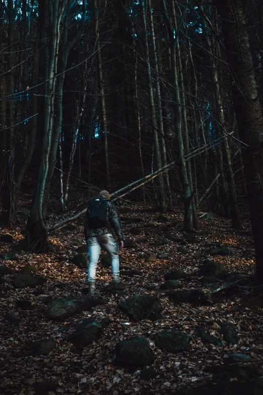 a man in the woods with a rope and some leaves on his feet