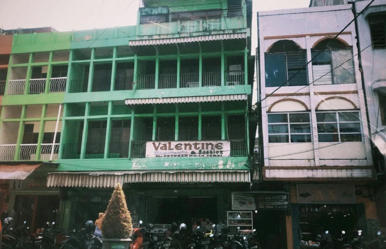 an old building is next to a street and has been altered with color