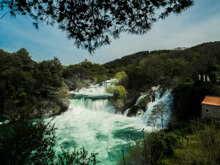 there is a waterfall surrounded by trees and green water