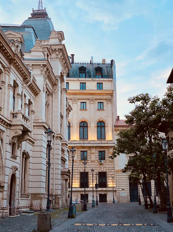 an image of two stone buildings on one side of the street