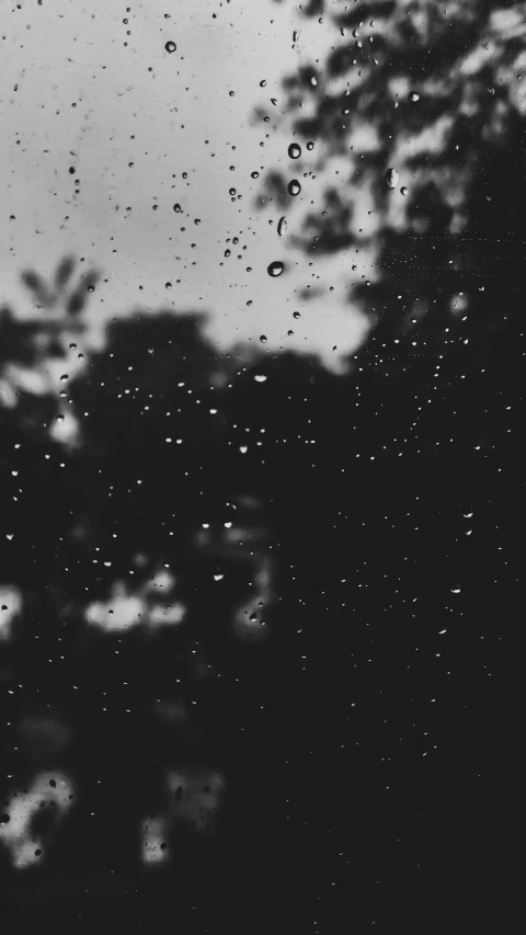 black and white image of rain drops on a window