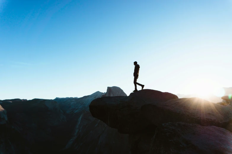 the person is standing at the top of the mountain