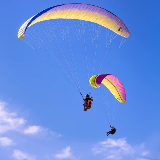 the sky is filled with kites as two people parachute