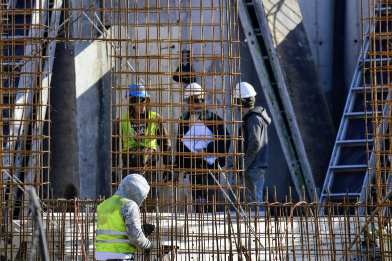 a group of construction workers standing on top of a building