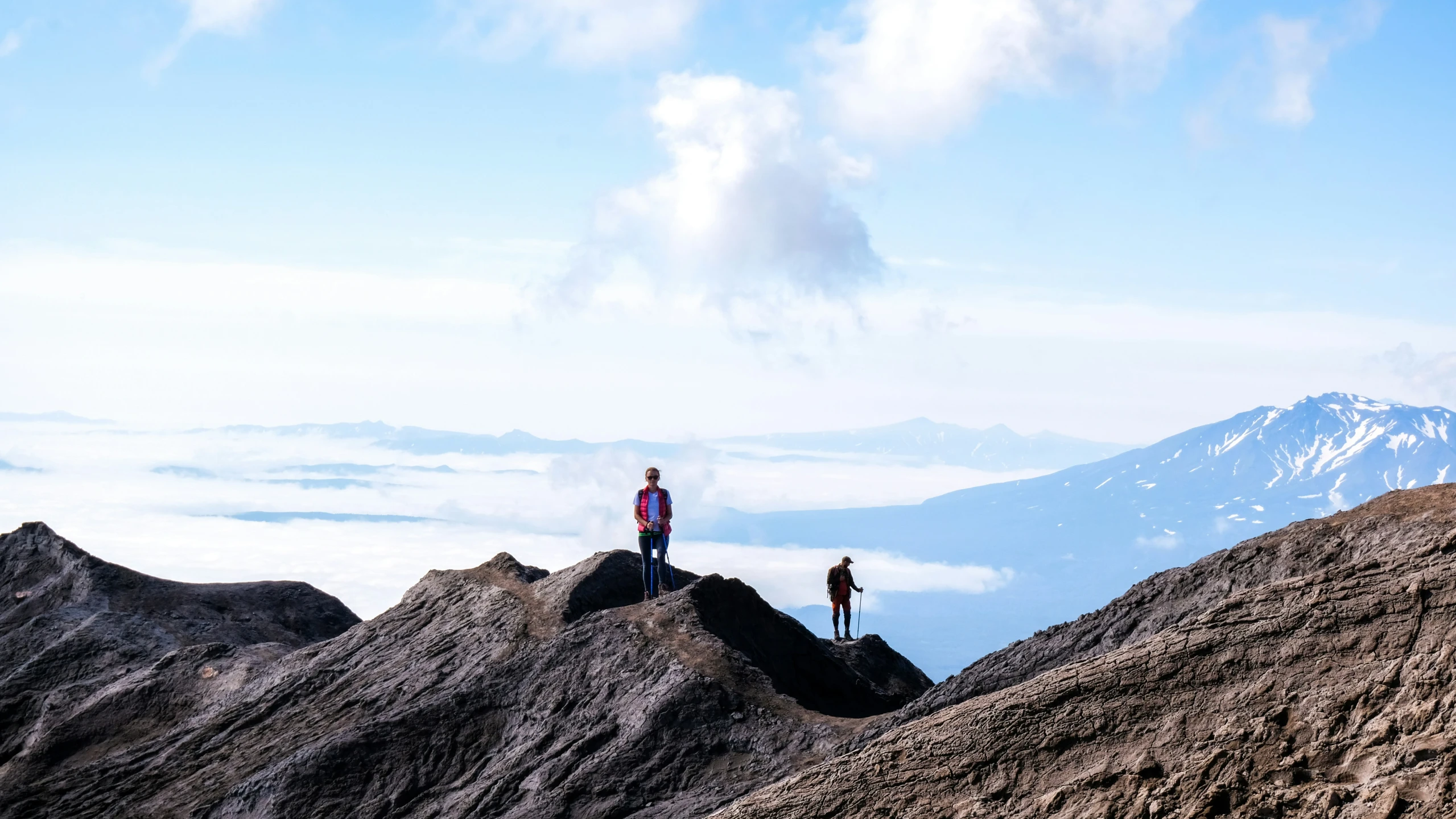 two people are standing on top of a mountain