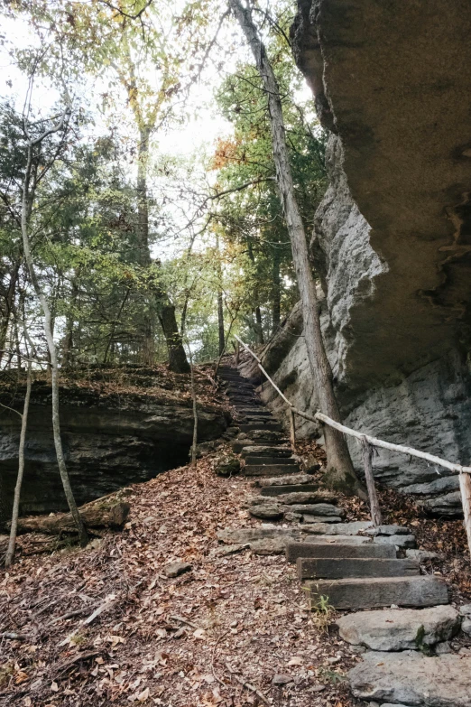 stone steps on the side of a cliff leading up to a small waterfall