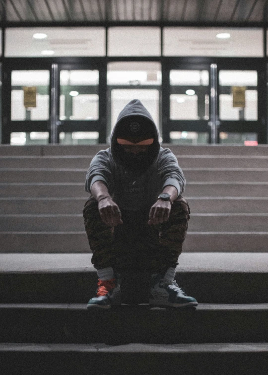 the man is sitting on a stairway in the building