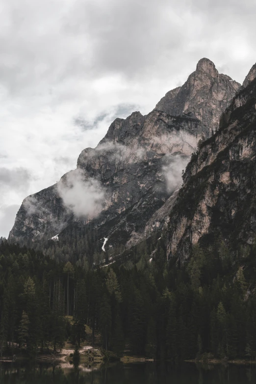 clouds hover over a mountain in the distance near water