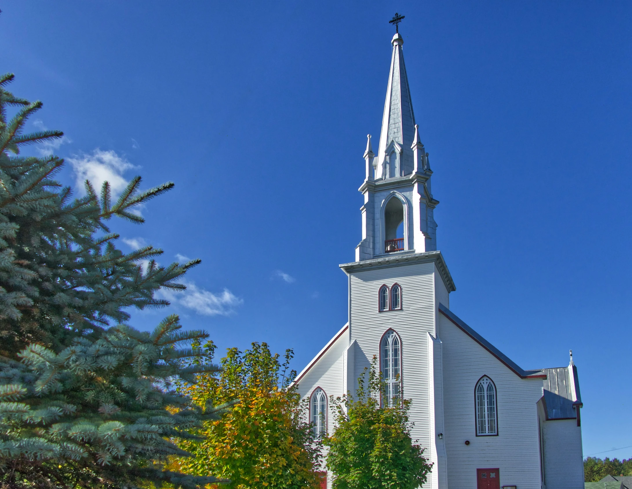 a church with white siding on a clear day