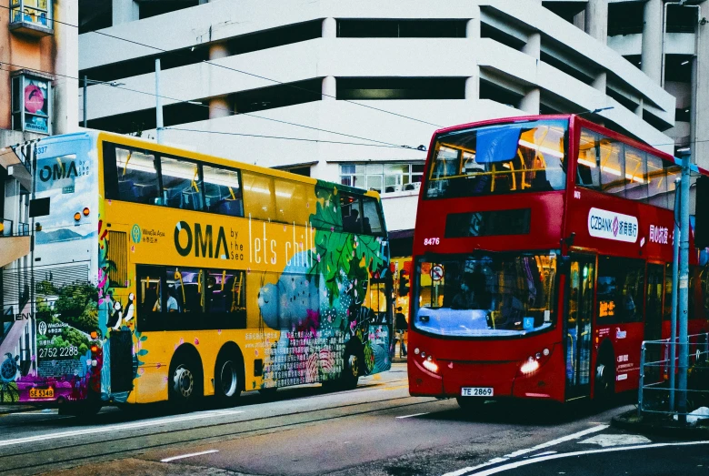 two big city buses are driving down the street