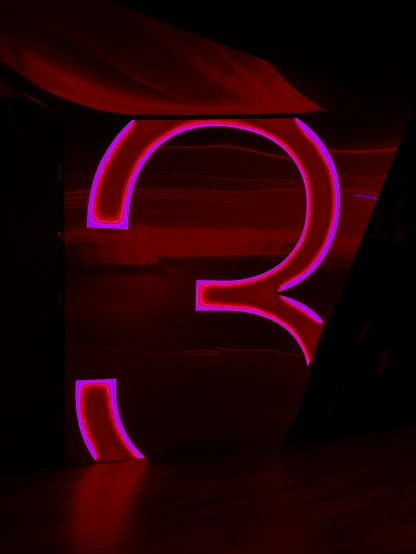 the neon letter q is in the dark