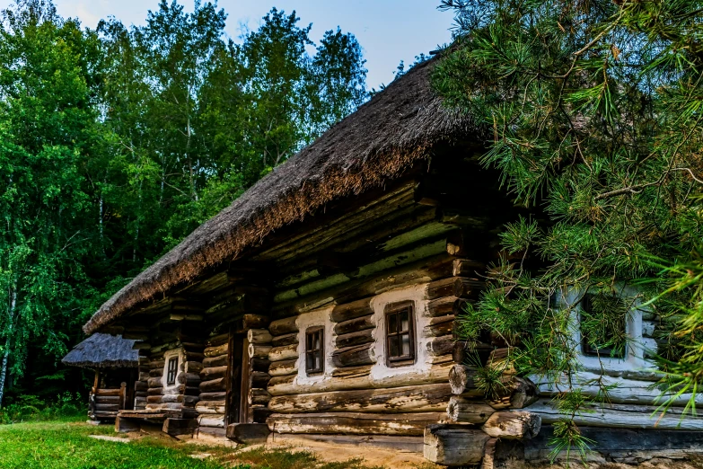 an old log cabin sitting near a field