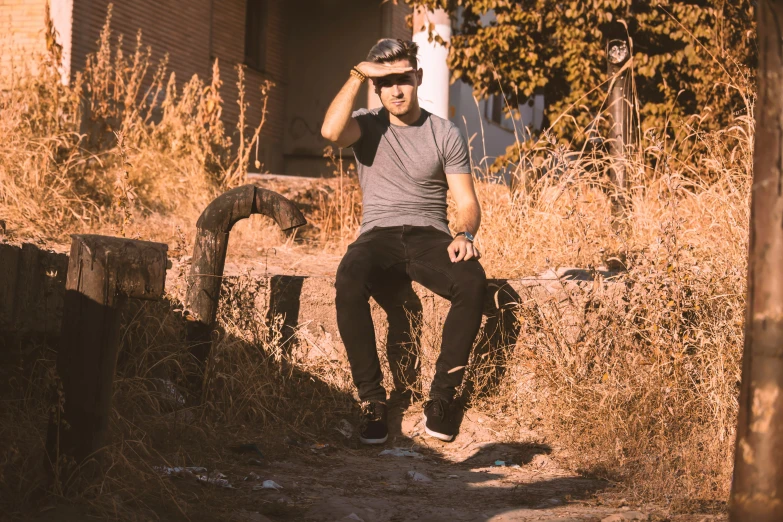 a person wearing a hat while leaning against a fence