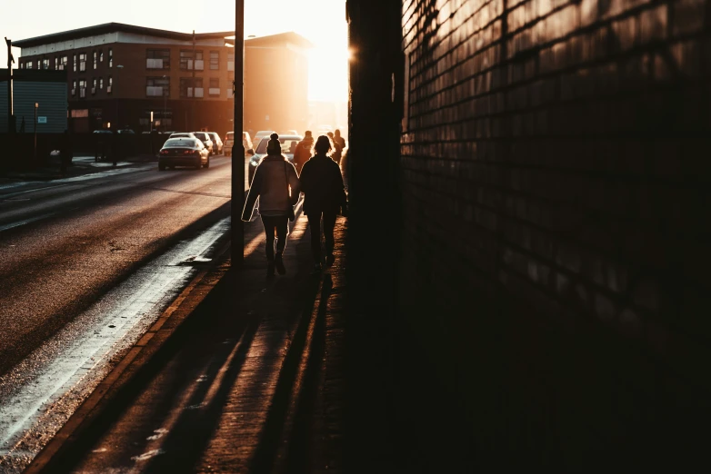 the sun's rays break through a window above a wall as pedestrians walk along a street