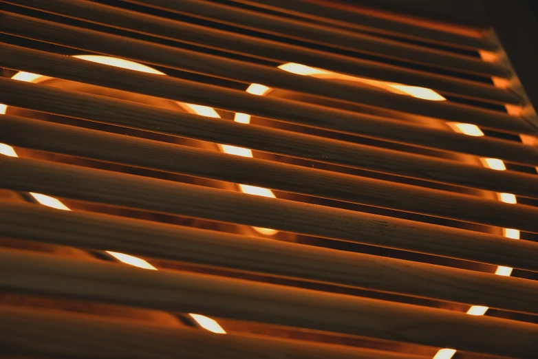 a close up of a window covering with light streaming in from it