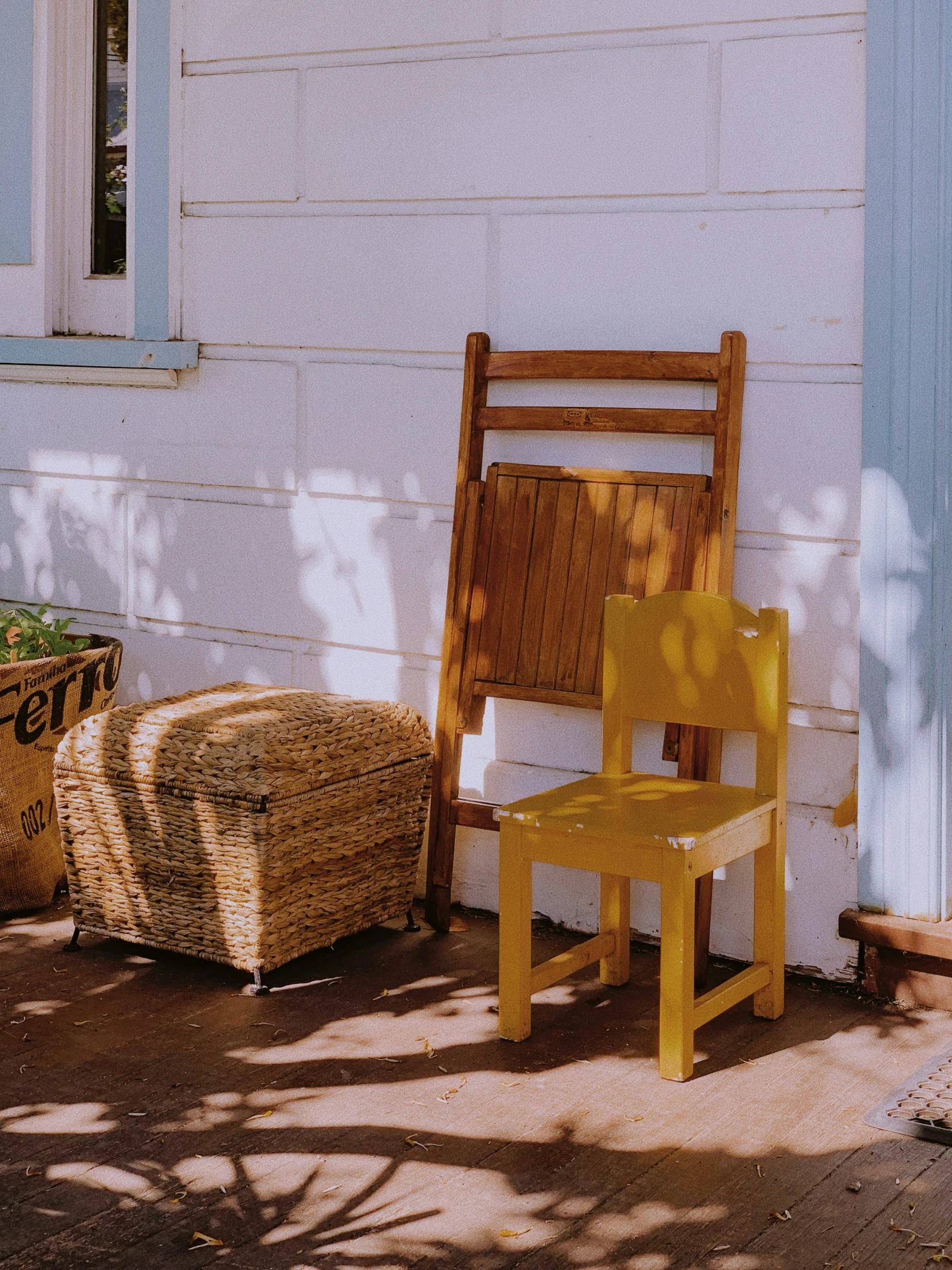 a wooden chair next to a building with hay