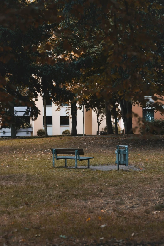 a bench on a grassy area in front of a large building