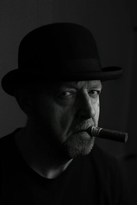 a man in black shirt and hat smoking a cigarette