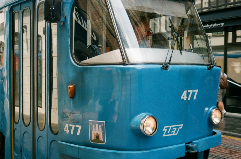 an old blue passenger train traveling down tracks