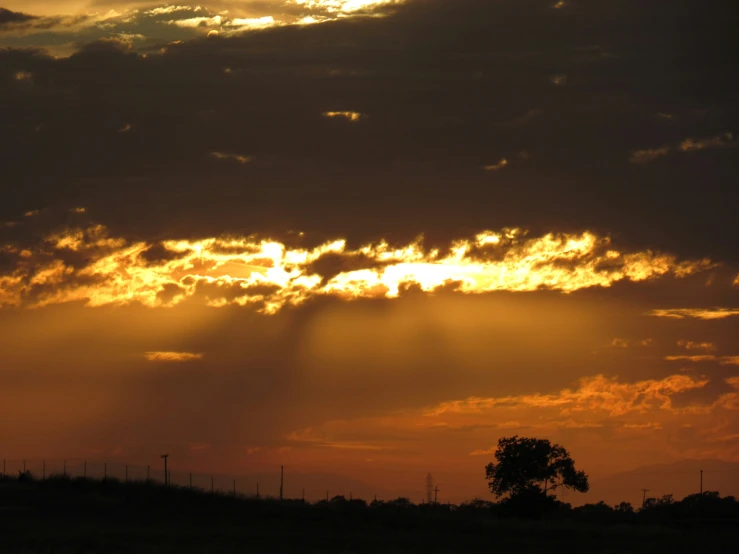 the sun setting behind a cloud in the sky