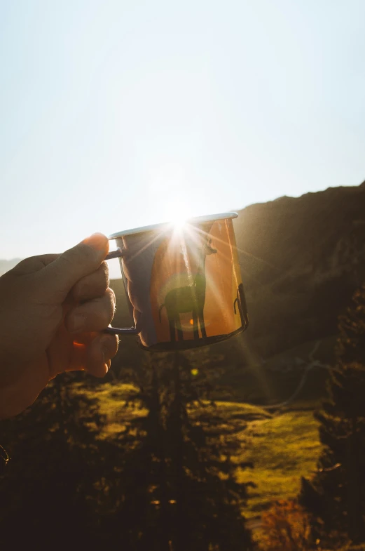 someone holding up a sun light mug to the camera