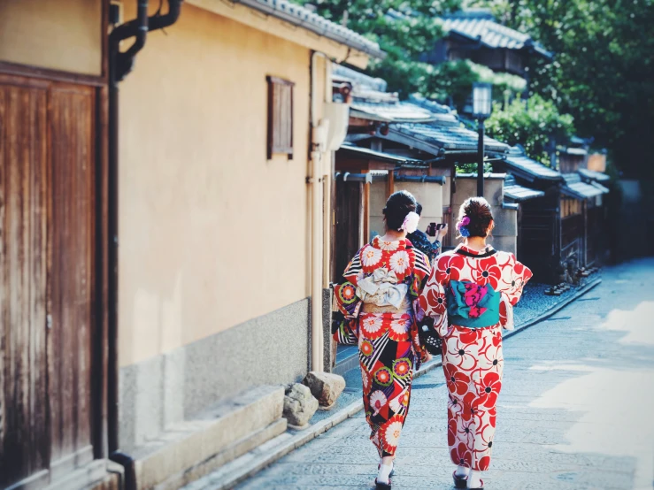 two people in kimonos walking down the street