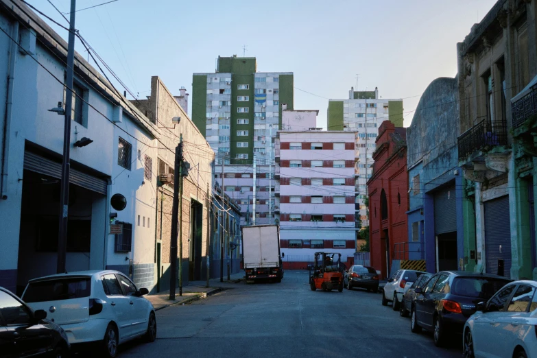 view down a residential area between parked cars and buildings